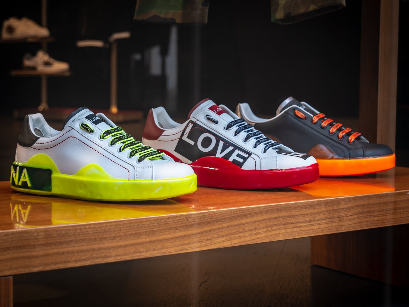 three unpaired multicolored leather sneakers on display